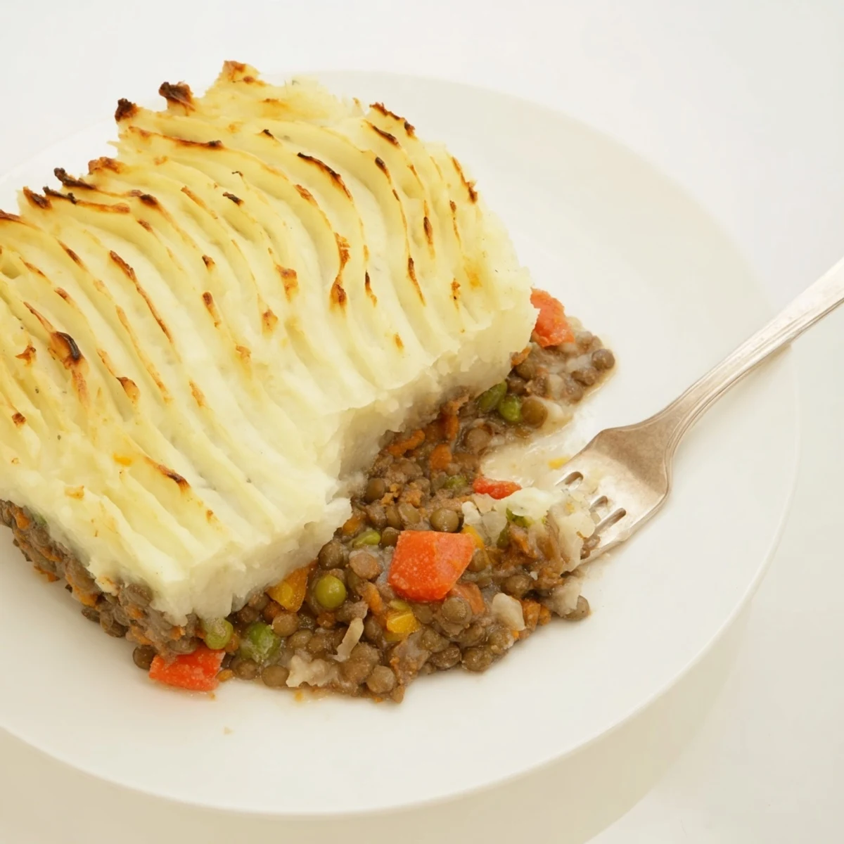 Savory Hearty Lentil Shepherd's Pie in a baking dish, perfectly baked with bubbly mashed potatoes.