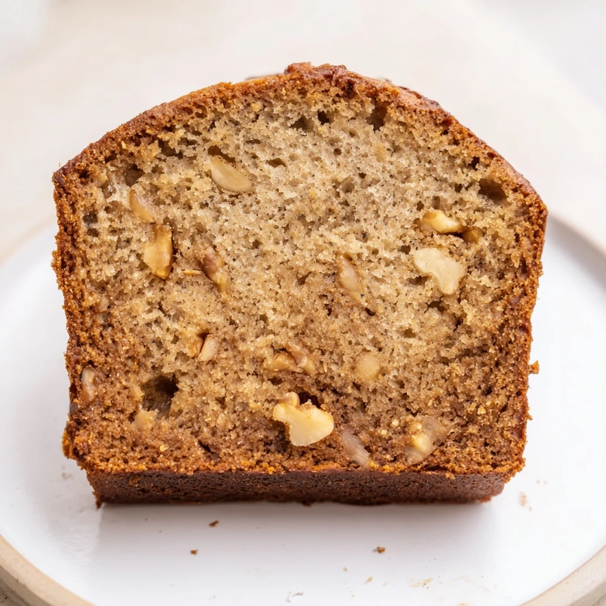 A warm and freshly baked Simple Banana Bread Loaf with a golden-brown top, ready to slice.