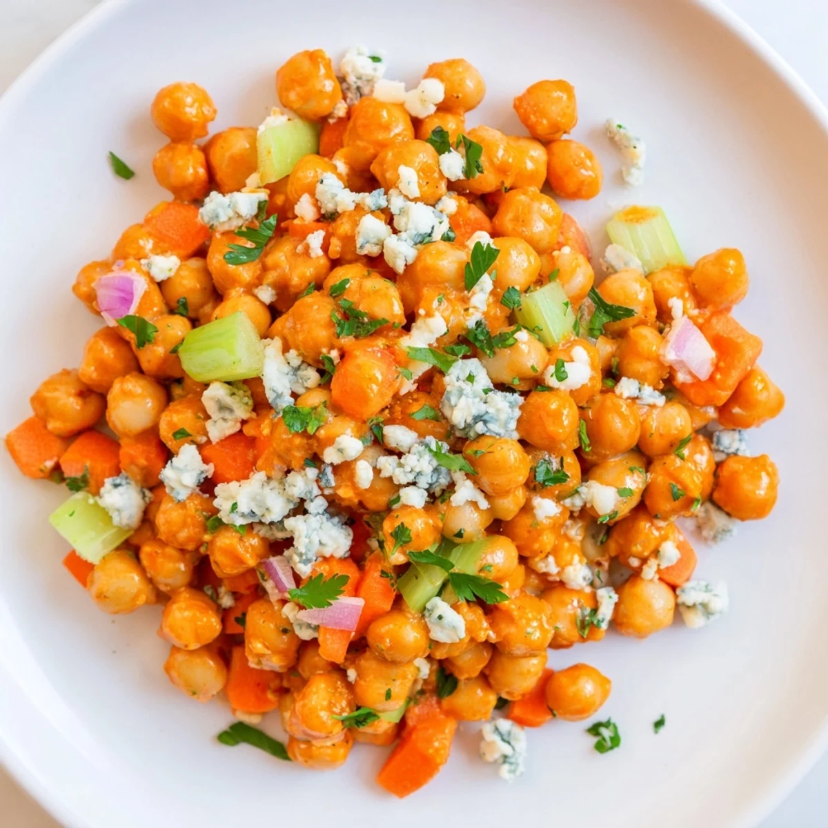 Vibrant photo showing buffalo chicken bean salad, with creamy blue cheese and fresh parsley garnish.