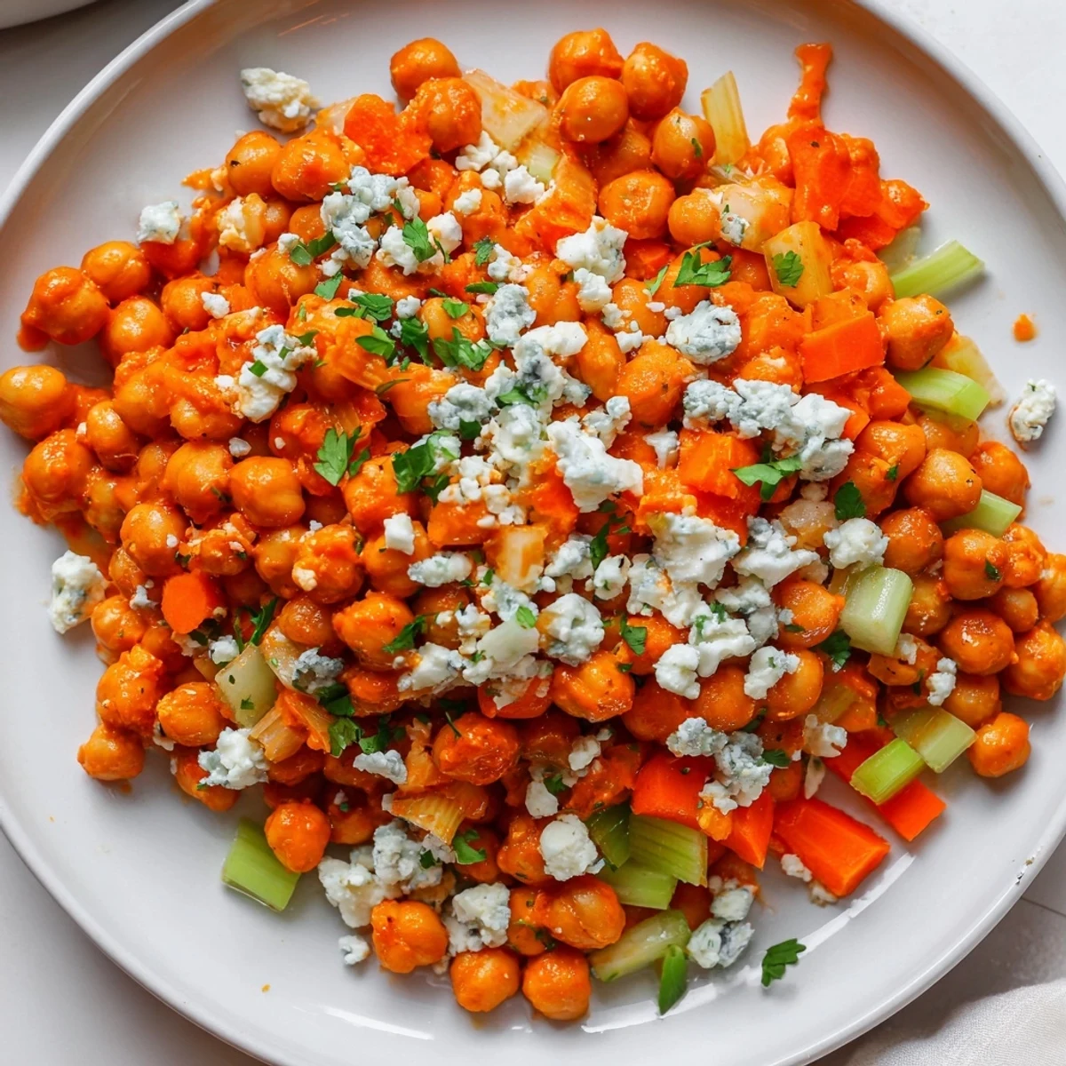 Spicy buffalo sauce coats the chickpeas in this flavorful buffalo chicken bean salad, ready for serving.