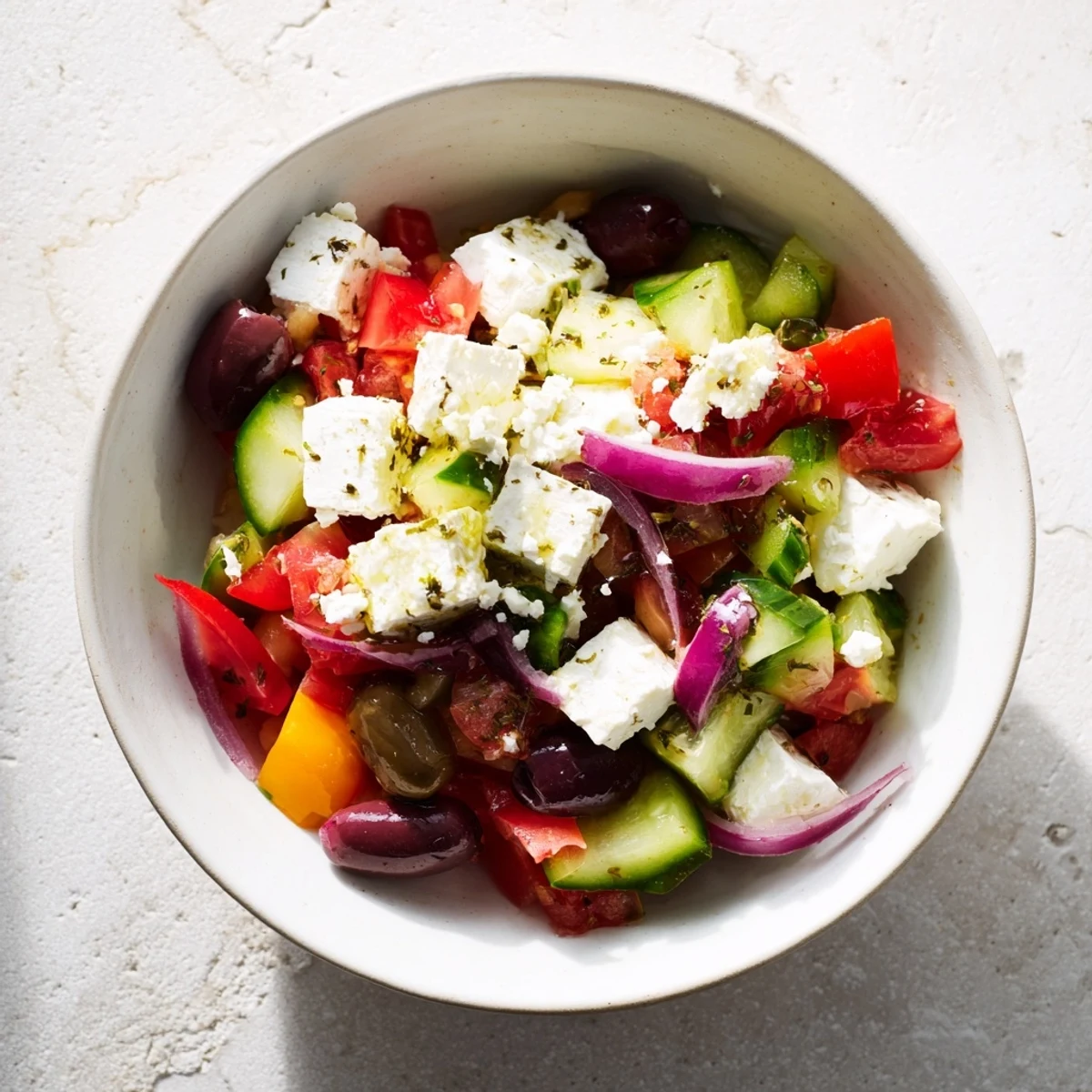 Mediterranean Chickpea and Feta Bowl, a colorful plate featuring fresh veggies and crumbled vegan feta.