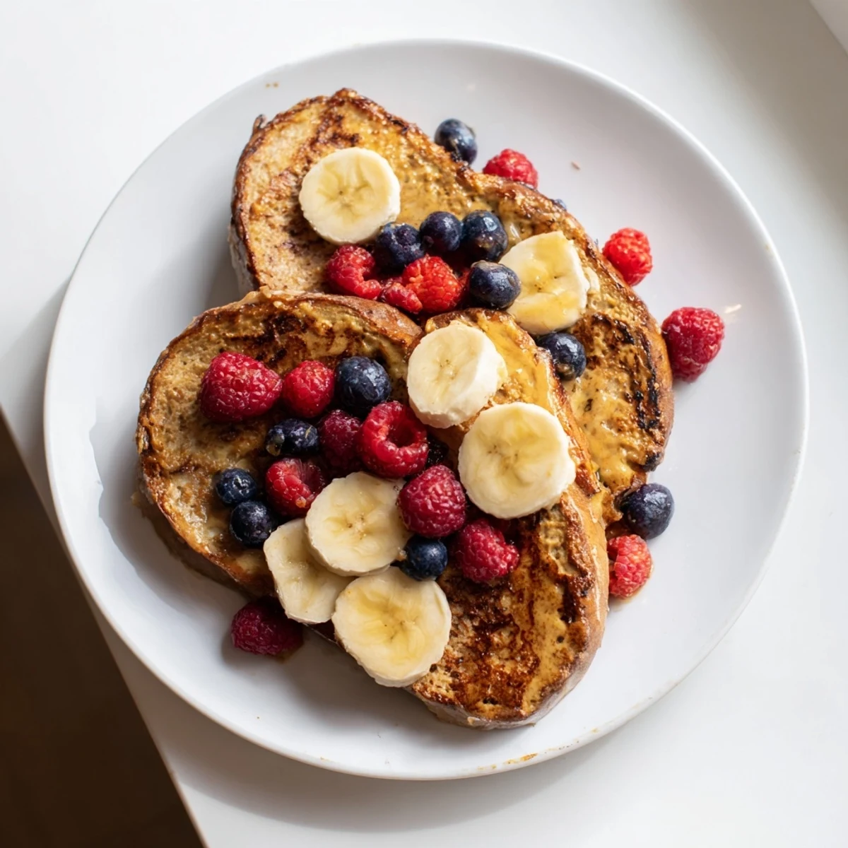 Fluffy Protein French Toast, golden brown with fresh berries, perfect for a protein-packed, delicious breakfast.
