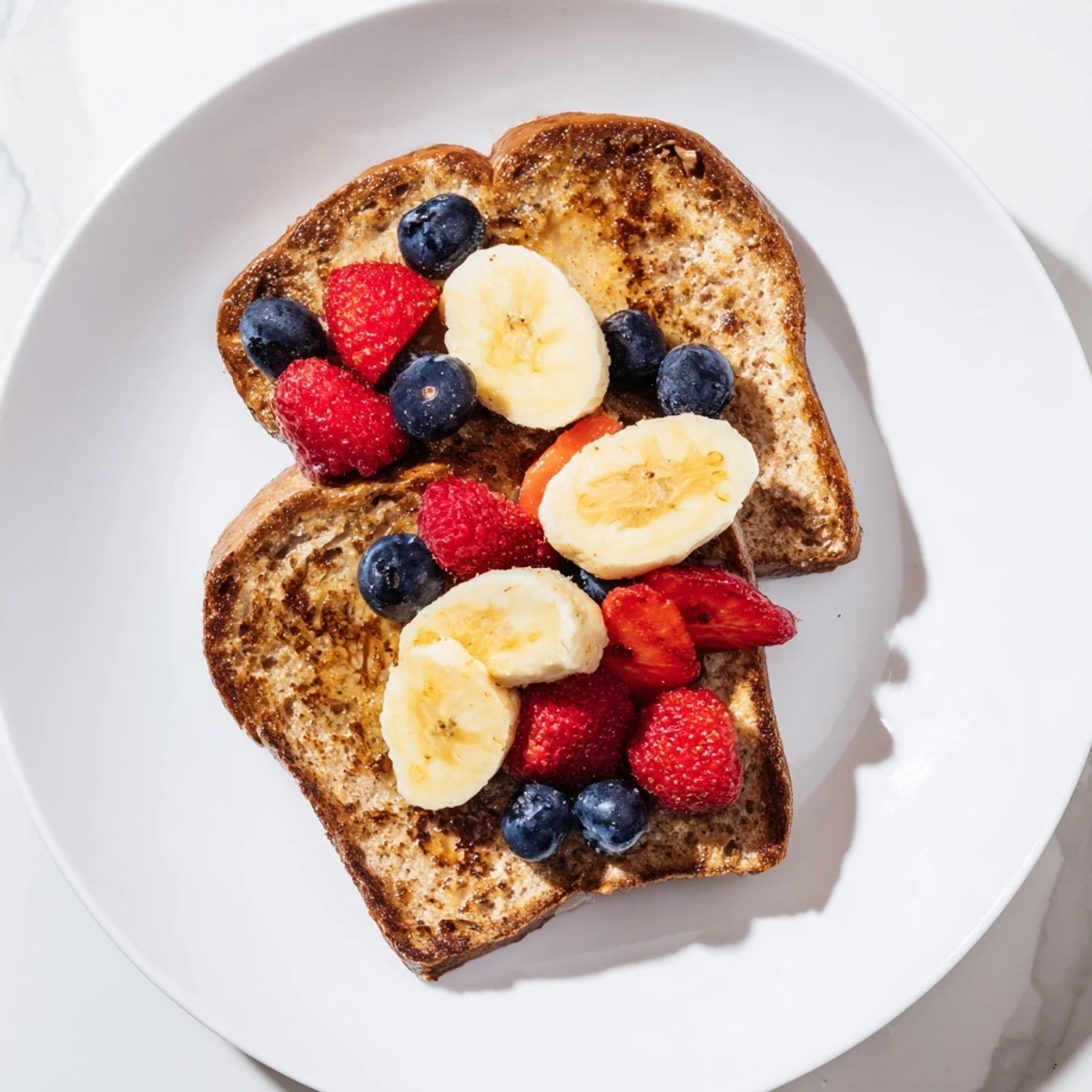 Warm, custardy Protein French Toast, cooked to perfection, is ideal with sliced bananas and creamy yogurt.