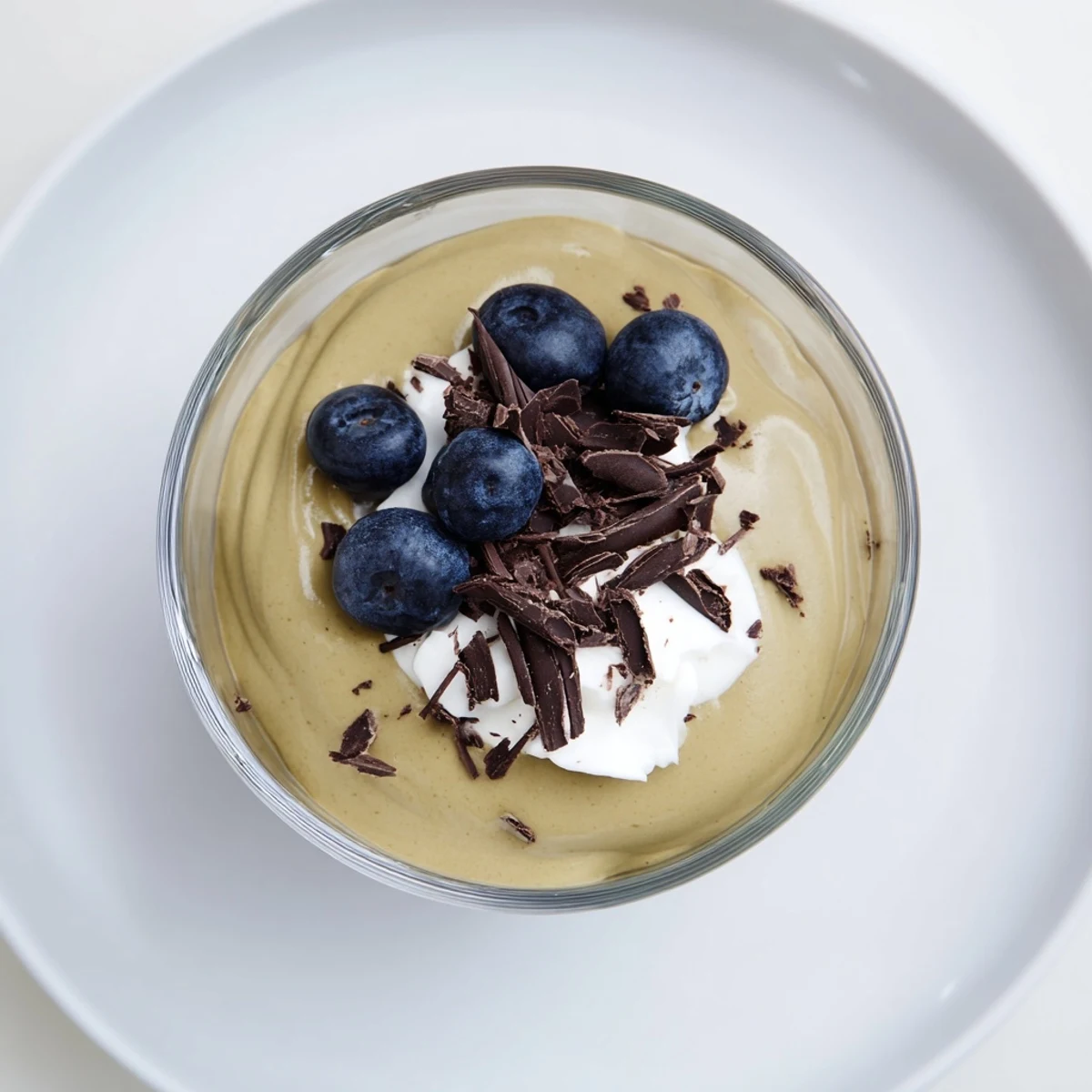 A close-up of smooth, rich avocado chocolate pudding, ready to be enjoyed with shaved chocolate.