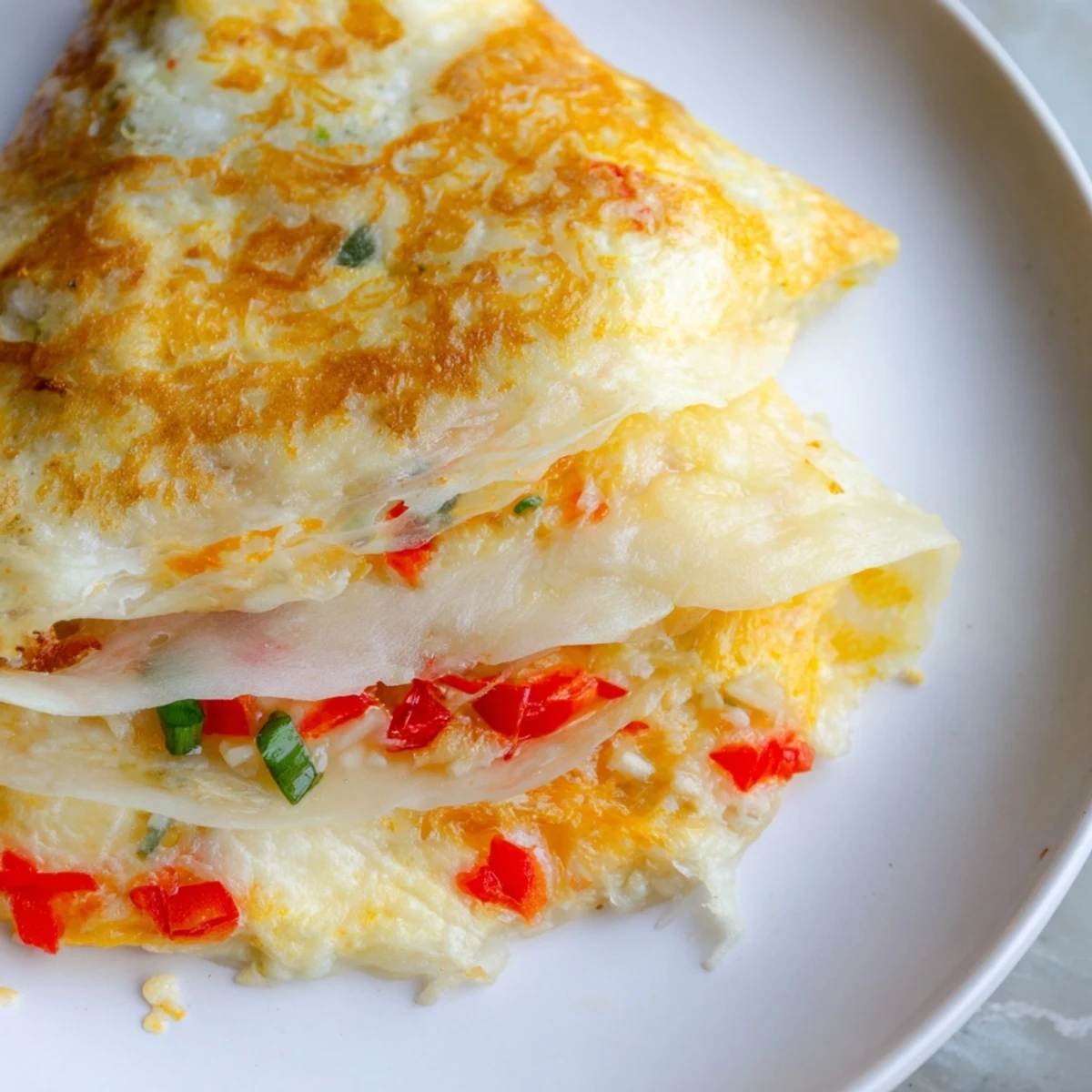 Golden-brown Rice Paper Egg Cheese Wrap, filled with melted cheese and crispy edges, ready to be enjoyed as breakfast.