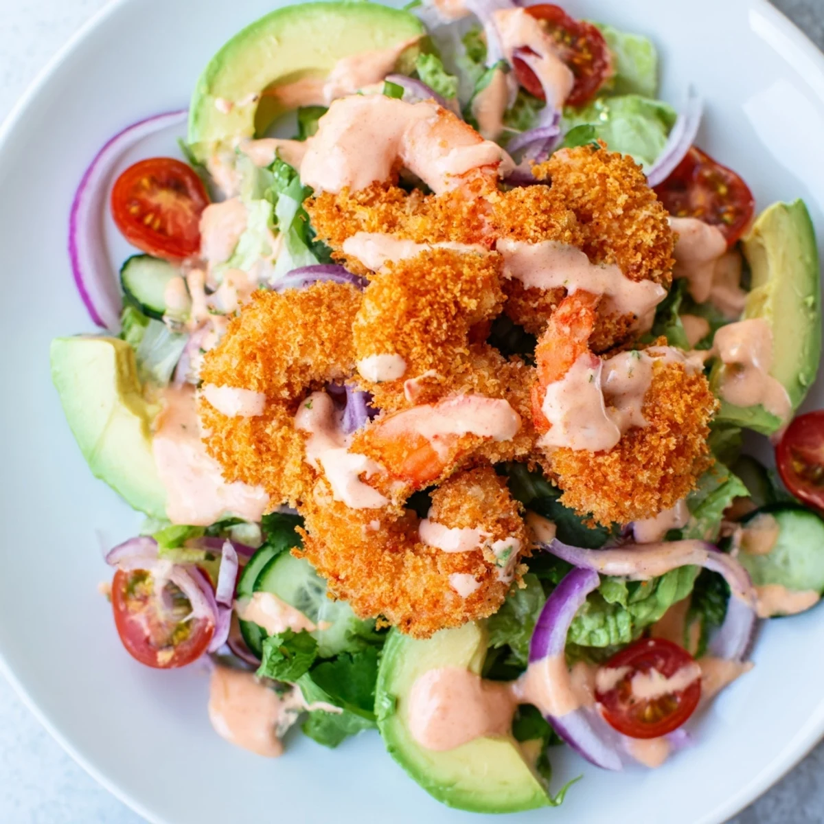 This Spicy Crispy Shrimp Salad shows perfectly fried shrimp atop a bed of romaine lettuce with a spicy lime dressing.