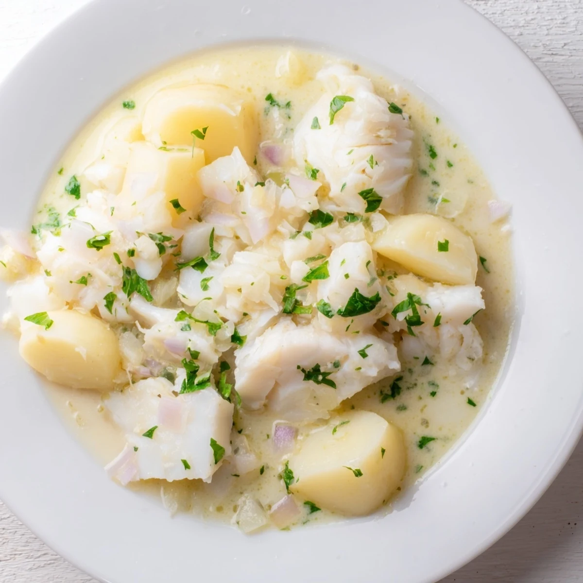 This hearty Icelandic Fish Stew shows a close-up of tender fish and potatoes in a creamy broth.