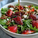 Vibrant Spring Dinner Party Strawberry Arugula Salad with Balsamic Glaze, featuring fresh strawberries, creamy goat cheese, and crunchy toasted pecans.
