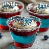 Festive 4th of July Firecracker Jello Shots showcase patriotic red, white, and blue hues.