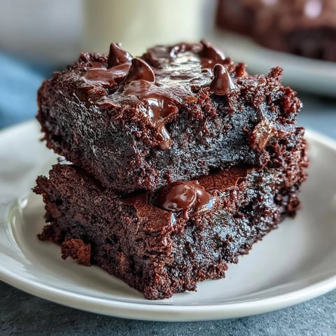 Freshly baked Greek Yogurt Brownies cooling on a wire rack with melted chocolate chips and chopped walnuts on top.