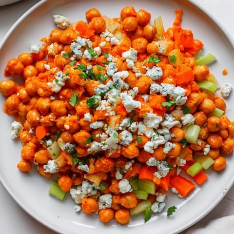 Spicy buffalo sauce coats the chickpeas in this flavorful buffalo chicken bean salad, ready for serving.
