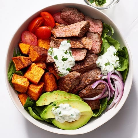 Savory Beef Avocado Sweet Potato Bowl featuring seared beef with fresh greens and a zesty lime dressing.