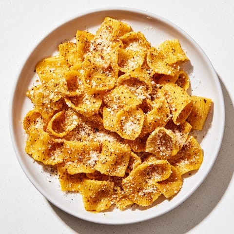 Air-fried pasta chips, a crunchy snack with Italian seasonings and a dusting of Parmesan cheese.