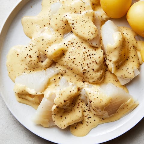 A plate of steaming Norwegian Lutefisk, glistening under the light, ready to be enjoyed.