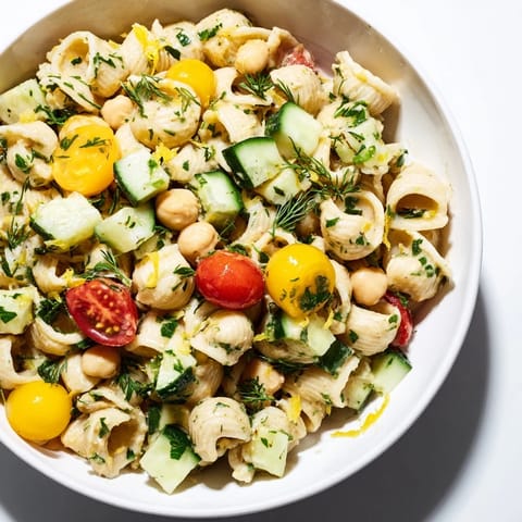 Zesty lemon herb chickpea pasta salad tossed with red onion, dill, mint, and a light olive oil dressing.  