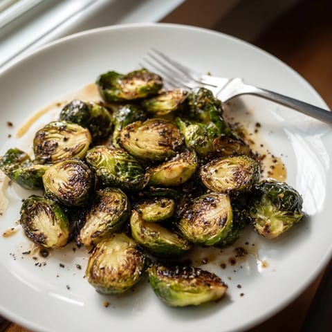 Freshly roasted Brussels sprouts tossed in olive oil and balsamic, glistening on a platter for an easy vegetarian side.