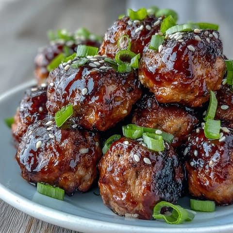 Glossy, oven-baked Spicy Chili Honey Turkey Meatballs coated in a sticky, sweet and spicy glaze on a platter.