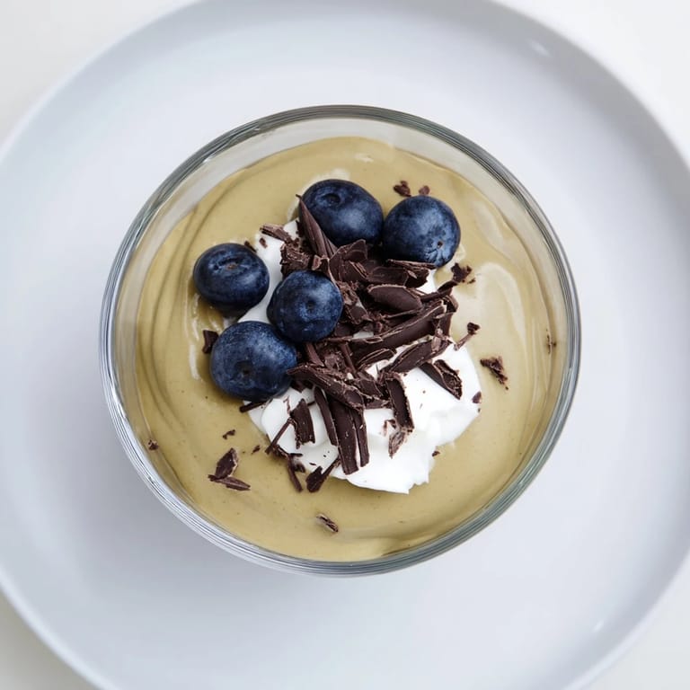 A close-up of smooth, rich avocado chocolate pudding, ready to be enjoyed with shaved chocolate.