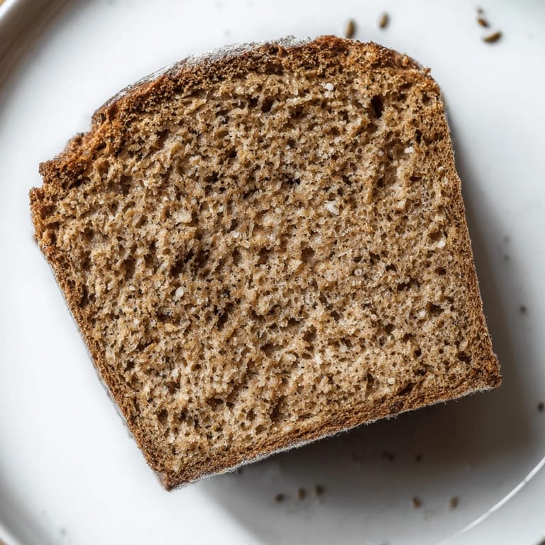A rustic image of warm, homemade Latvian Rupjmaize bread, ready to slice for a delicious meal.